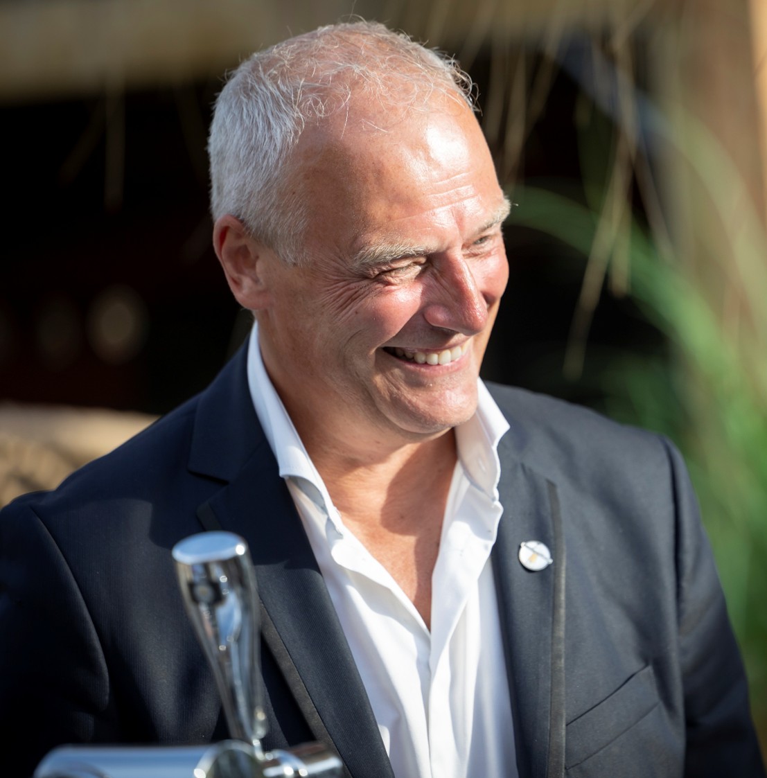 Portret van Eric de Kock, glimlachend in een donker colbert